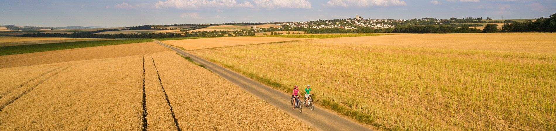 Kopfbild Saisonübersicht Luftbild Radfahrer im Feld